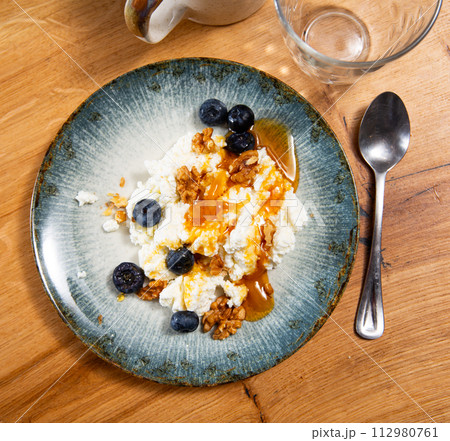 Farm cottage cheese filled with large amount of honey with walnut and blueberry. Farm cottage cheese filled with large amount of honey with walnut and blueberry. 112980761
