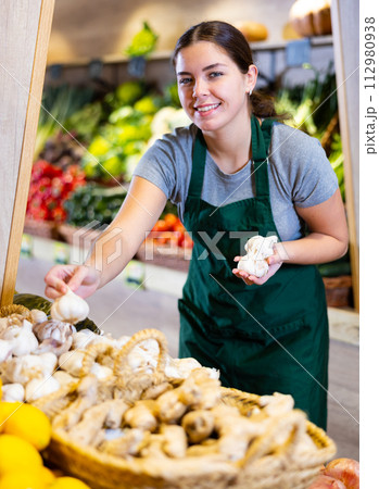 Young woman selling garlic in shop 112980938