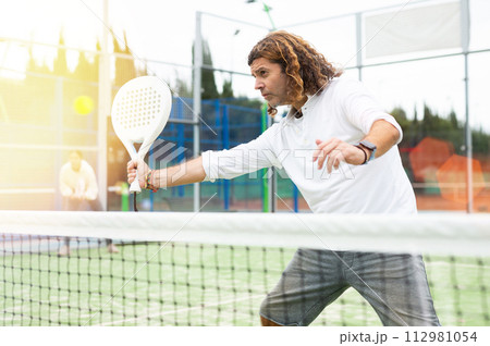 Man training to play tennis on padel court outdoor 112981054