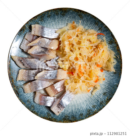 Slices herring fish with pickled cabbage, served on plate 112981251