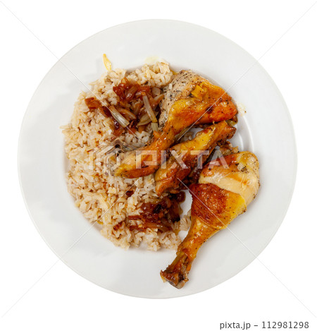 Boiled rice with vegetable gravy and piece of fried chicken is served on large white platter 112981298