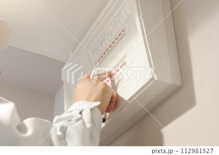 配電盤の検査をする作業服の男性 112981527