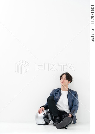 ヘルメットを持って座る男性ライダー 112981601