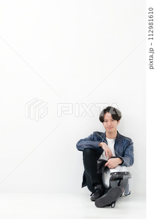 ヘルメットを持って座る男性ライダー 112981610