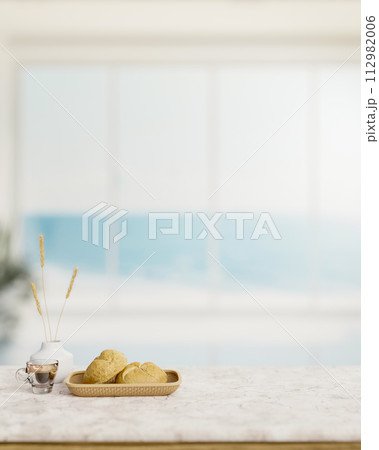 A bread basket and a coffee cup on a white marble table in a modern white beach house living room. 112982006