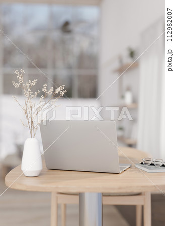 A laptop computer on a wooden table in a beautiful contemporary living room. 112982007