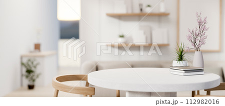 A space for displaying products on a white round table in a cozy contemporary living room. 112982016