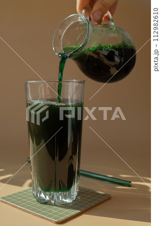 Organic blue-green algae spirulina detox drink in glass powder food. Health protein cocktail smoothie of chlorella. Vitamins and minerals to diet. Prebiotic and antioxidant rich Dietary supplement 112982610