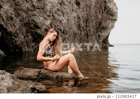 Woman travel sea. Happy tourist enjoy taking picture outdoors for memories. Woman traveler swim in the sea bay with mountains, sharing travel adventure journey 112983417