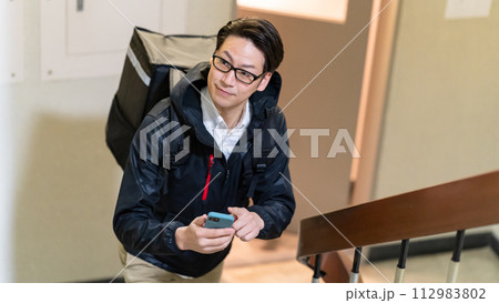 フードデリバリーをする男性 112983802