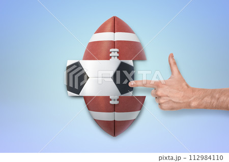 Finger pointing at an American football-soccer ball Finger pointing at an American football-soccer ball 112984110
