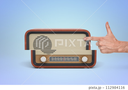Retro radio with hand pointing at dial Retro radio with hand pointing at dial 112984116