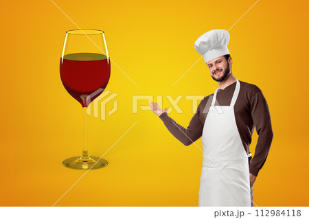 Chef presenting a giant wine glass Chef presenting a giant wine glass 112984118