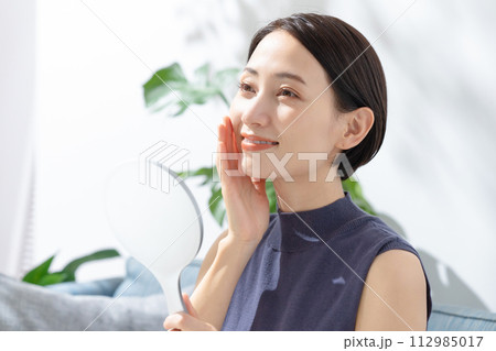 手鏡を見る女性 112985017