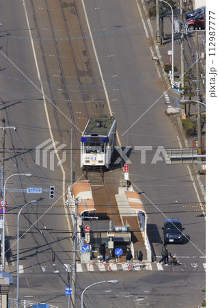 【縦構図・人物ナンバーロゴレタッチ済み】函館市電　谷地頭電停に進入、出発の様子 112987777
