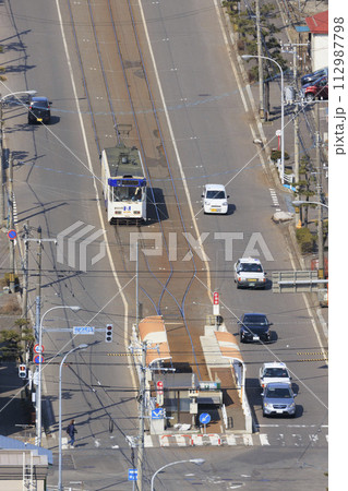 【縦構図・人物ナンバーロゴレタッチ済み】函館市電　谷地頭電停に進入、出発の様子 112987798