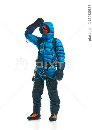 Winter tourism. Man wearing protective goggles, gloves, boots and special equipment for mountain climbing isolated on white background Winter tourism. Man wearing protective goggles, gloves, boots and special equipment for mountain climbing isolated on white background 112988988