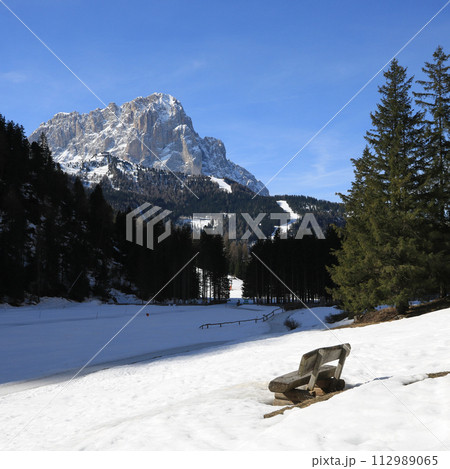 Wooden bench with view of the Langkofel, mountain in South Tirol. 112989065