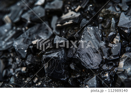 Black Anthracite close up photo. Hard coal black glossy texture crystals. Dark stones industrial mining fossil production raw coal ecology detailed macro photo 112989140
