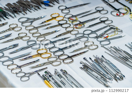 Set of many different scissors for manicure. Metal scissors on a white background. Close-up 112990217