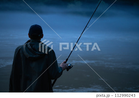 Man fishing on the mountain river at evening 112990243