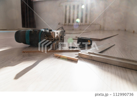 Sawing laminate. Repairing the floor in the house, laminate flooring. 112990736