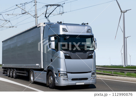 Electric semi truck with pantograph takes energy from wires above the highway Electric semi truck with pantograph takes energy from wires above the highway 112990876