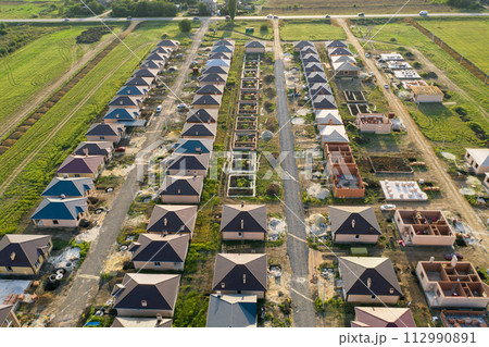 Construction of a suburban neighborhood of cottages. Aerial view. Construction of a suburban neighborhood of cottages. Aerial view. 112990891