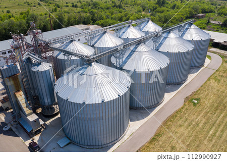 Aerial view of agricultural silos, grain elevator for storage and drying of cereals. Aerial view of agricultural silos, grain elevator for storage and drying of cereals. 112990927
