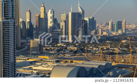 Dubai downtown skyline timelapse at sunset time. Rooftop view of Sheikh Zayed road with numerous towers. 112991635