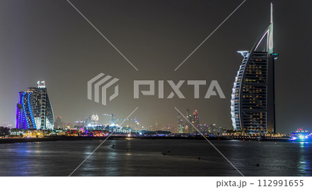 Dubai skyline with Burj Al Arab hotel at night timelapse. 112991655