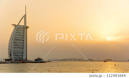 Dubai skyline with Burj Al Arab hotel during sunset timelapse. 112991664