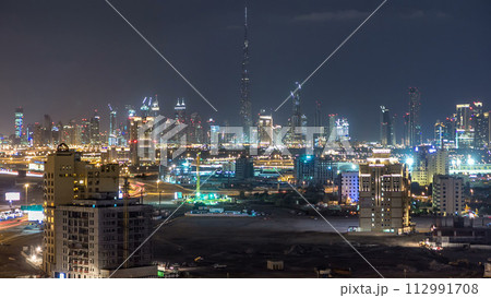Dubai downtown skyline timelapse at night. Rooftop view of Sheikh Zayed road with numerous illuminated towers. 112991708