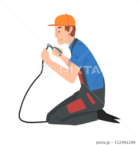 Male Electrician Engineer Sitting on His Knee Repairing Cable with Pliers, Electricity Maintenance Service Worker Character in Uniform and Cap Cartoon Style Vector Illustration 112992296