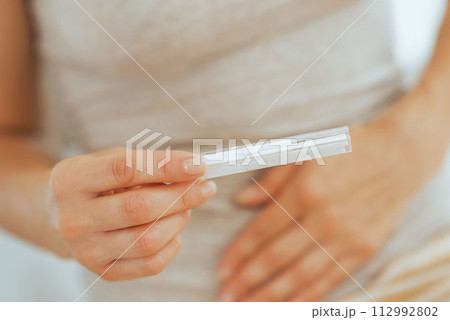 Closeup on young woman holding pregnancy test 112992802