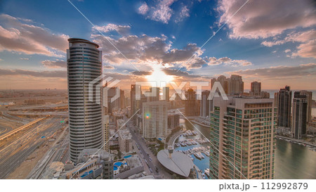 Modern skyscrapers and water channel with boats of Dubai Marina at sunset timelapse, United Arab Emirates. 112992879