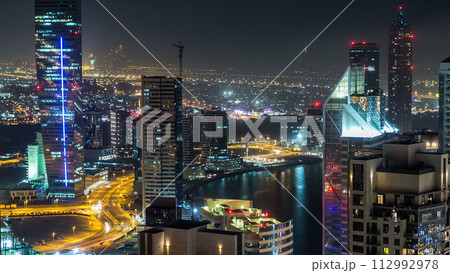 Aerial view of a big modern city at night timelapse. Business bay, Dubai, United Arab Emirates. 112992978