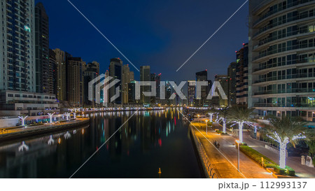 Dubai Marina towers and canal in Dubai night to day timelapse 112993137