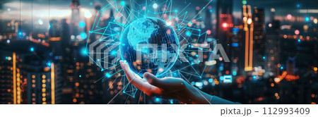 A futuristic globe-shaped holographic graphic is displayed on the left hand and blurs the atmosphere during the early hours of a future city. banner picture.  112993409