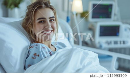 Happy young woman smiling and feeling recovered after getting an emergency surgery at the hospital 112993509