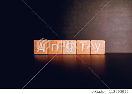 Wooden blocks form the text "Angry" against a black background. Wooden blocks form the text "Angry" against a black background. 112993935