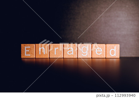 Wooden blocks form the text "Enraged" against a black background. Wooden blocks form the text "Enraged" against a black background. 112993940