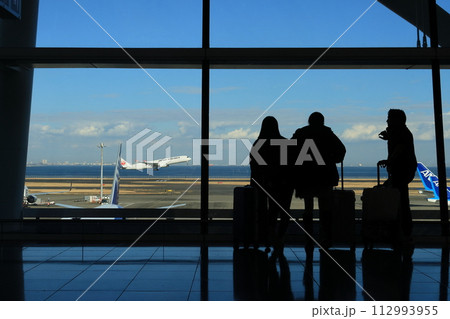 羽田空港第2ターミナル国際線ロビー 飛行機を眺める乗客 男女 羽田空港第2ターミナル国際線ロビー 飛行機を眺める乗客 男女 112993955
