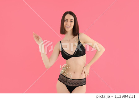 Slim girl in underwear with flowers, on a pink background. 112994211