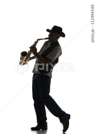 Silhouette of man in classical suit playing saxophone isolated on white background. Black and white image. Silhouette of man in classical suit playing saxophone isolated on white background. Black and white image. 112994589