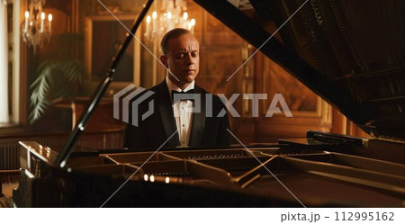 young talented male in formal suit professionally play piano. classical music performer practice playing piano before performance 112995162