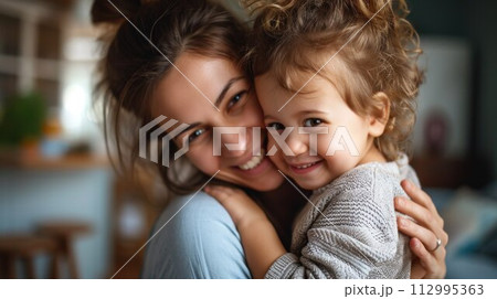 Affectionate loving middle aged mother cuddling child. Excited to see daughter, happy senior older mom cuddling her, sitting together on comfortable sofa in living room 112995363