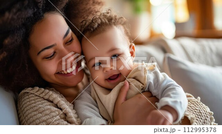 mother cuddling her baby with smile on their faces and adorable look on baby face mother cuddling her baby with smile on their faces and adorable look on baby face 112995378