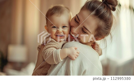 mother cuddling her baby with smile on their faces and adorable look on baby face 112995380