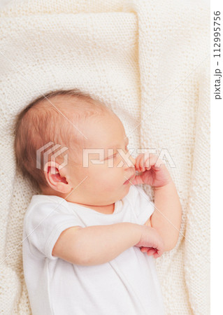 Newborn Baby Asleep on Cream Blanket Newborn Baby Asleep on Cream Blanket 112995756